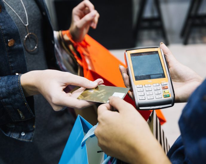 Customer making a contactless card payment at a retail terminal, representing AI-driven checkout optimization and reduced transaction friction.