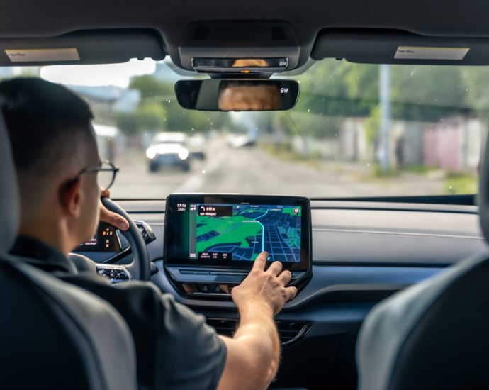 Driver interacting with a smart navigation system inside a connected car, illustrating real-time IoT data processing and generative AI-powered decision support.