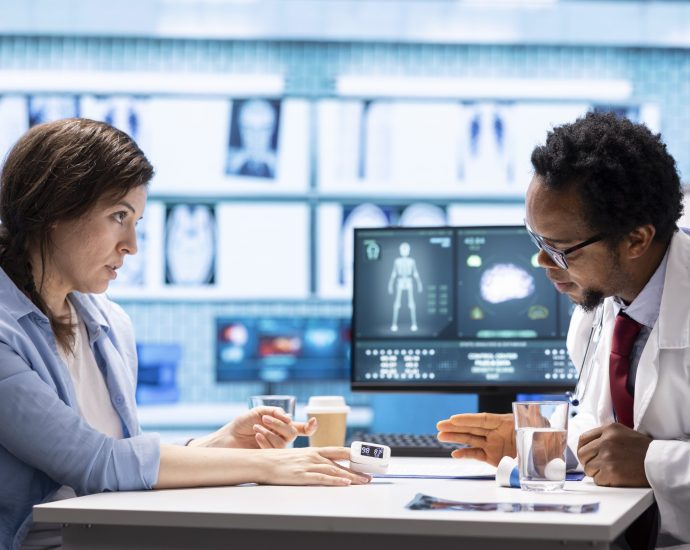 Doctor reviewing patient vitals with advanced monitoring tools, highlighting HIPAA-compliant data integrity powered by AI-driven predictive analytics.