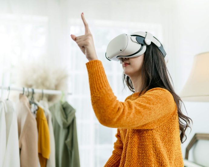 Woman using a virtual reality headset to experience augmented reality shopping and virtual try-on for fashion in an eCommerce environment.