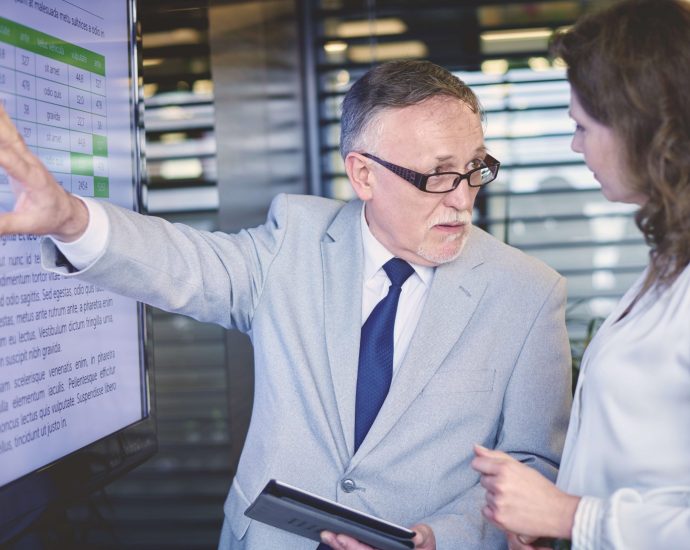 Business professionals analyzing data on screen to ensure compliance and improve claims review accuracy with AI support