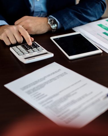 Financial professional reviewing loan documents and calculating credit data, illustrating automated credit processing and faster loan approval workflows using LLM orchestration.