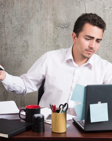 Overworked professional reviewing documents manually, highlighting compliance risks and inefficiencies in claims processing without AI automation