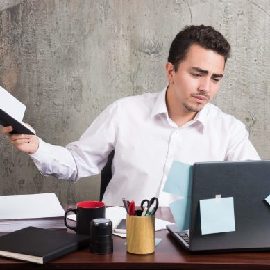 Overworked professional reviewing documents manually, highlighting compliance risks and inefficiencies in claims processing without AI automation
